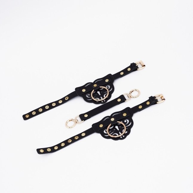 Черные кожаные оковы с резными узорами и клепками. Фотография 3.