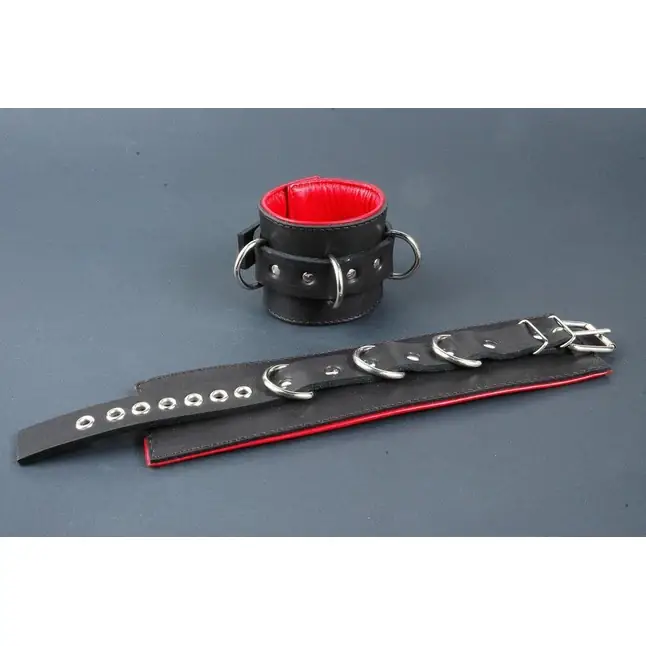 Поддвернутые чёрные наручники с застежкой-ремешком и красной изнанкой